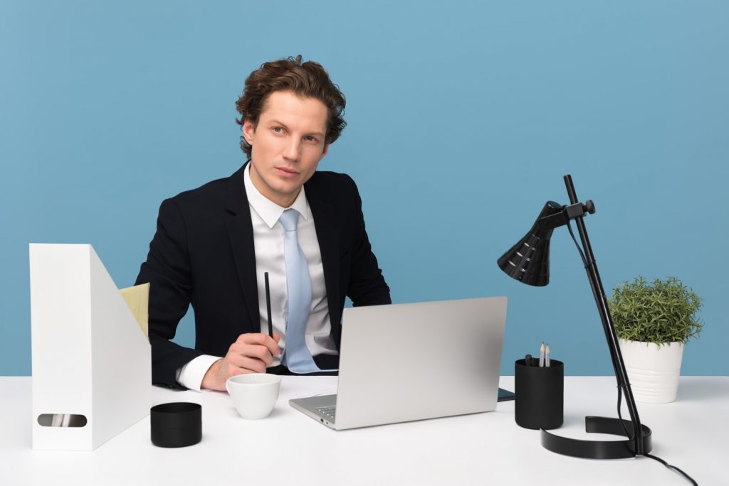 back office manager man sitting on chair beside laptop computer and teacup